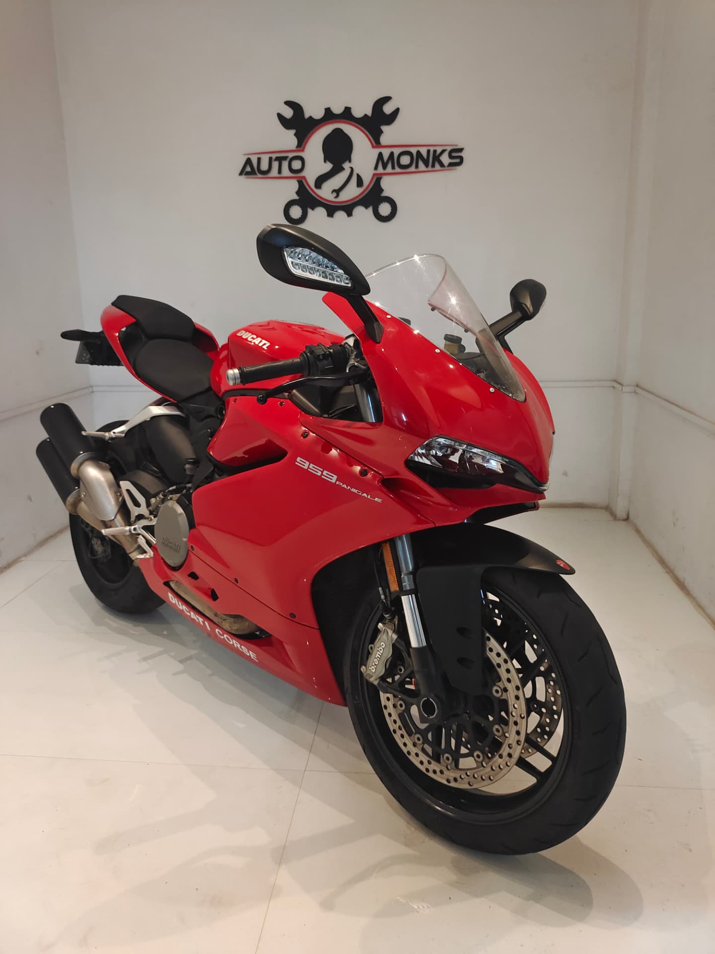 Ducati Panigale parked under the AUTO MONKS logo at the workshop